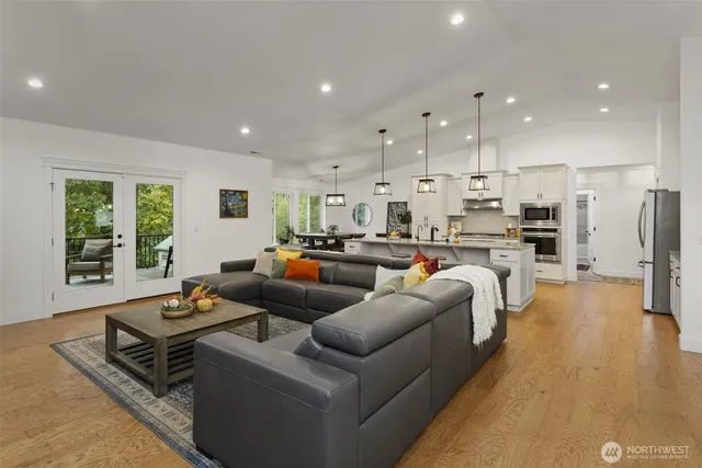 a living room with furniture kitchen and a large window