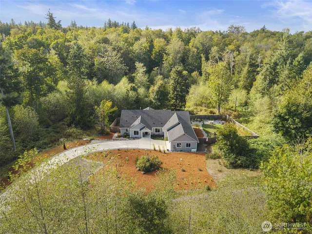 a view of a house with a yard and a large tree