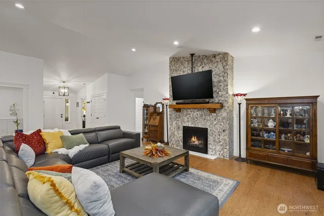 a living room with furniture a flat screen tv and a fireplace