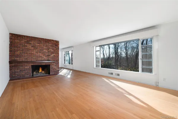 a view of an empty room with a fireplace and a window
