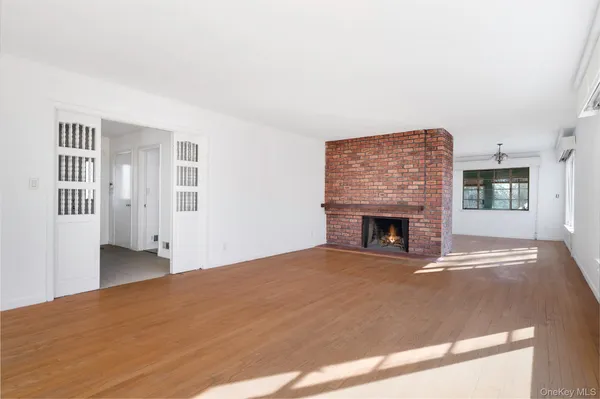 a view of an empty room with a fireplace and a window