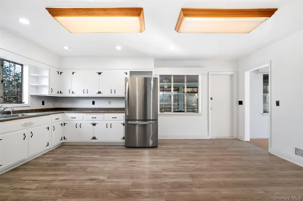 a kitchen with granite countertop white cabinets and refrigerator