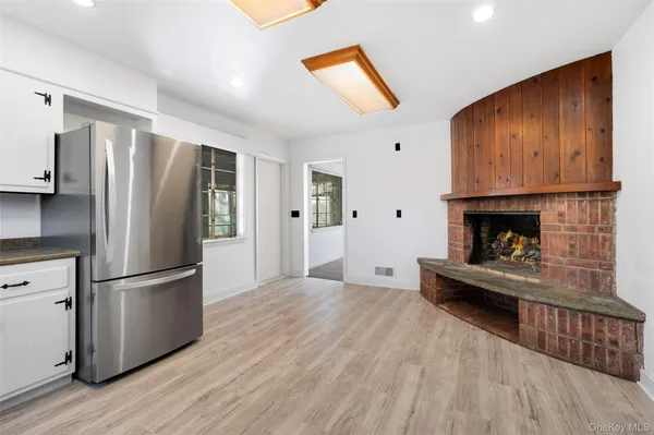 a kitchen with stainless steel appliances granite countertop a refrigerator microwave and wooden floor