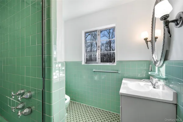 a bathroom with a sink a toilet and a mirror