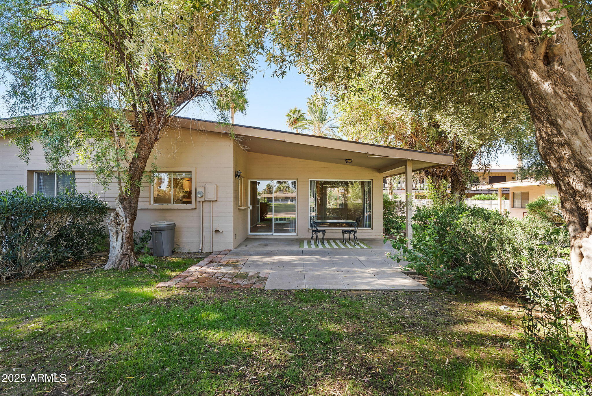 a view of a patio with table and chairs under an umbrella