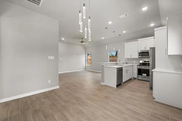 a kitchen with a refrigerator and a stove top oven