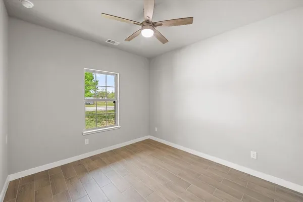 an empty room with a window and a ceiling fan