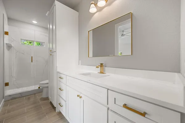 a bathroom with a sink a toilet and shower
