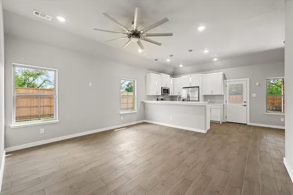 a view of a kitchen with wooden floor and windows