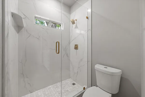 a bathroom with a toilet and a shower