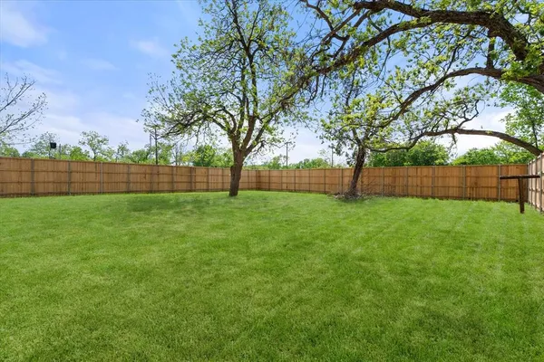 a view of yard with green space and wooden fence
