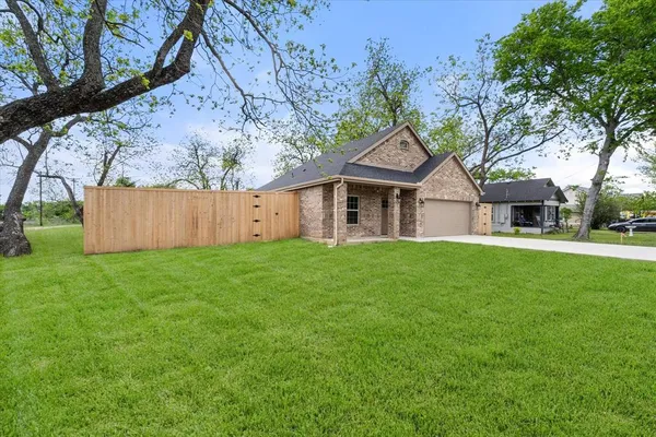 a front view of a house with a garden and yard