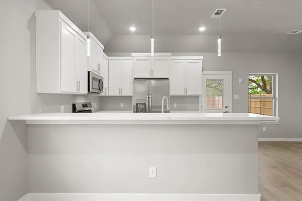 a kitchen with kitchen island granite countertop a sink cabinets and window