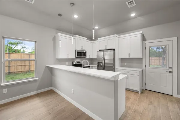 a kitchen with white cabinets and white appliances