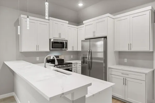 a kitchen with white cabinets and stainless steel appliances