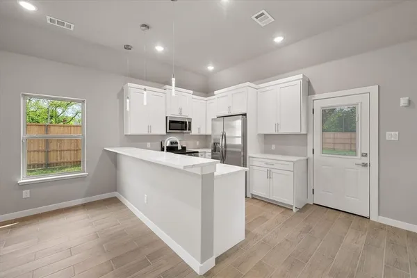 a kitchen with white cabinets and white appliances