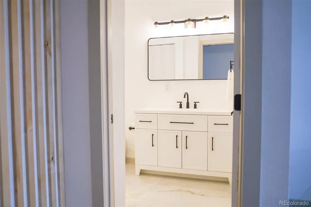 a bathroom with a sink vanity and a mirror
