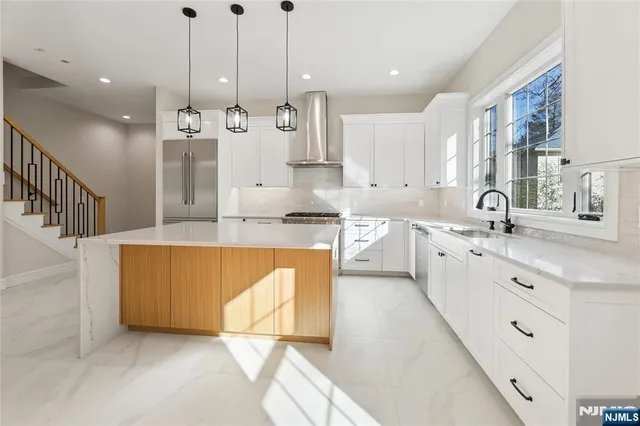 a large kitchen with stainless steel appliances kitchen island granite countertop a sink a counter top space and cabinets