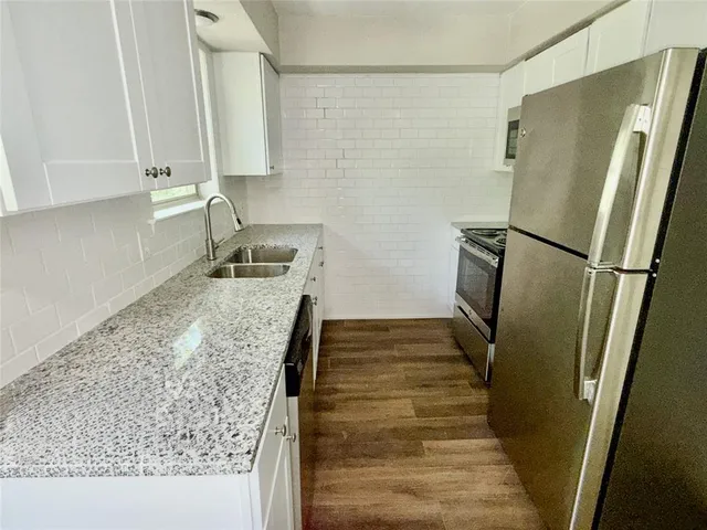 a kitchen with a refrigerator and a sink