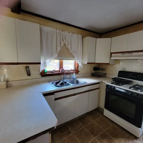 a kitchen with stainless steel appliances a stove a sink and a microwave