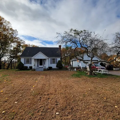 a front view of a house with a yard covered in snow
