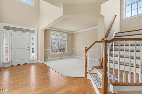 a view of an empty room with wooden floor fireplace and a window