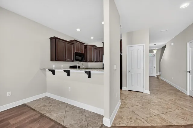 a view of a kitchen with refrigerator and white cabinets