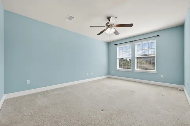 a view of an empty room with a ceiling fan