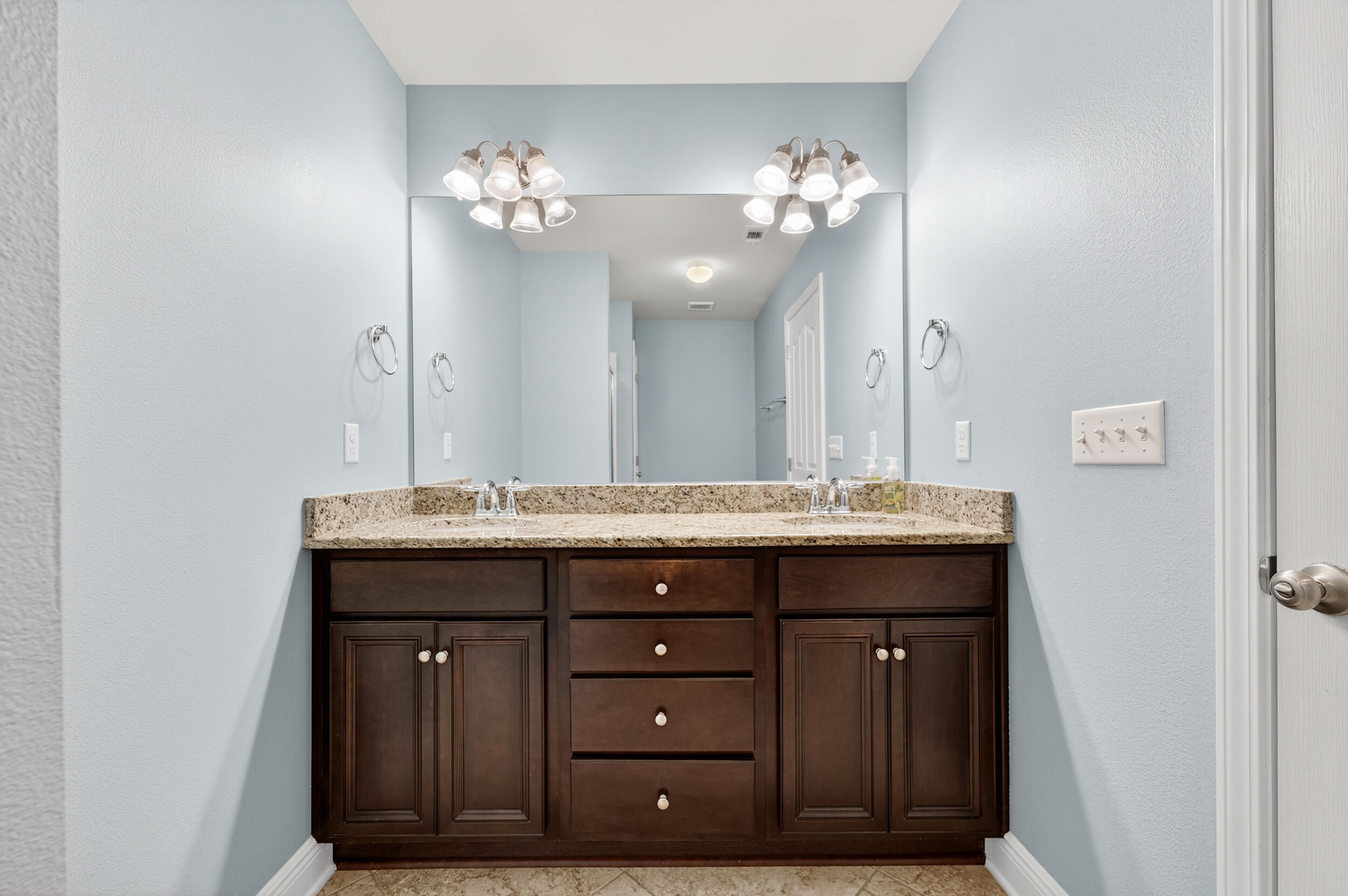 8900 White Ibis Way Navarre, FL 32566 - Photo 26 of 37 a bathroom with a granite countertop sink a large mirror and a vanity