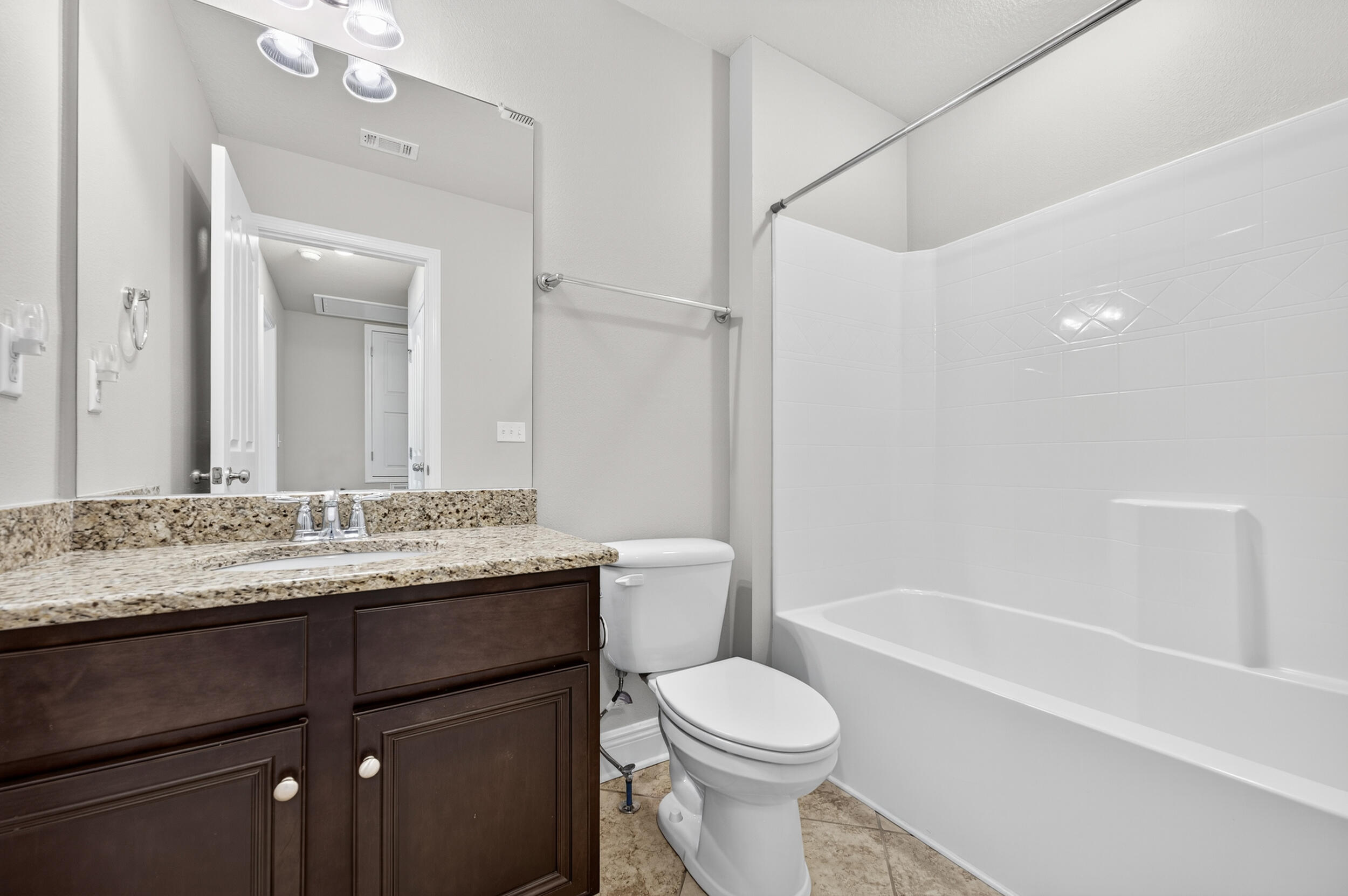 8900 White Ibis Way Navarre, FL 32566 - Photo 32 of 37 a bathroom with a granite countertop sink toilet a large mirror a bathtub and shower