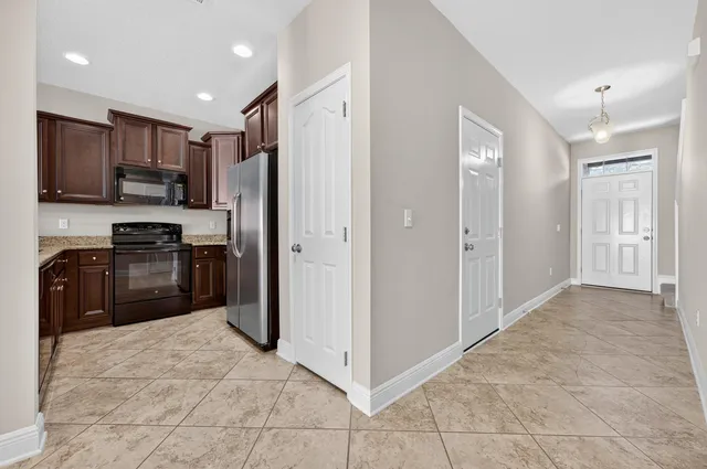 a kitchen with stainless steel appliances granite countertop a refrigerator and a stove top oven