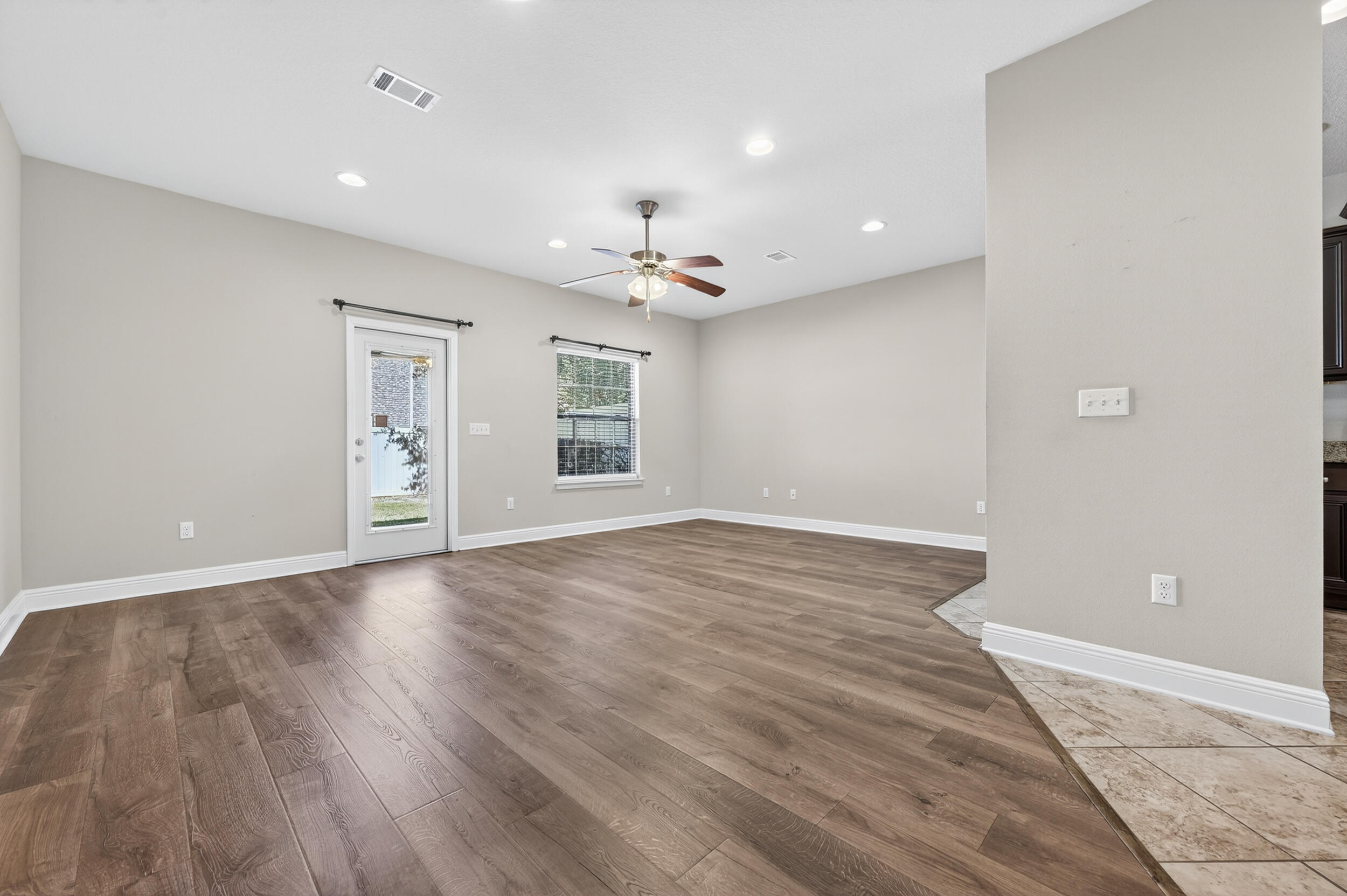 8900 White Ibis Way Navarre, FL 32566 - Photo 6 of 37 wooden floor in an empty room with a window