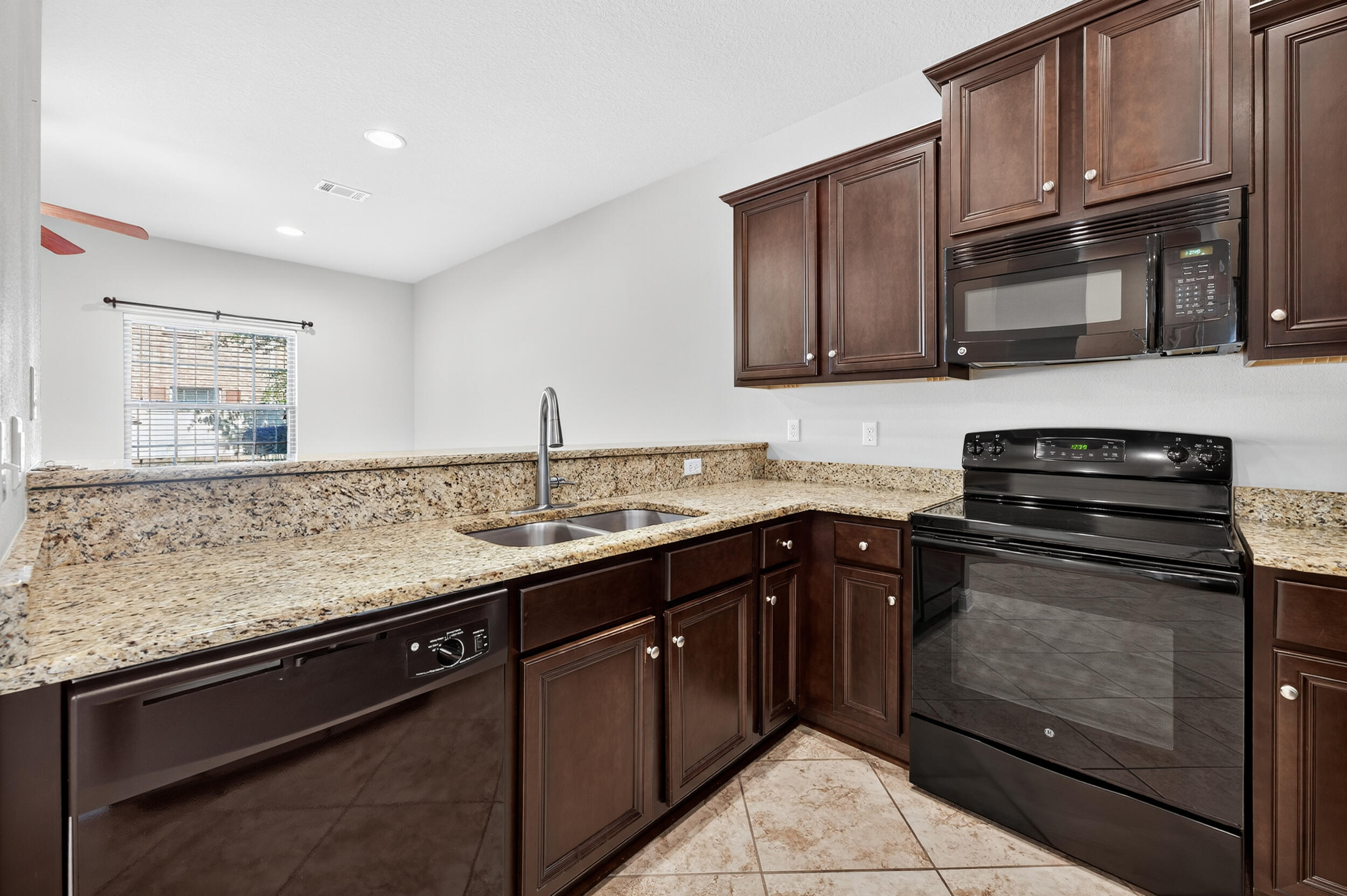 8900 White Ibis Way Navarre, FL 32566 - Photo 7 of 37 a kitchen with stainless steel appliances granite countertop a stove microwave and sink