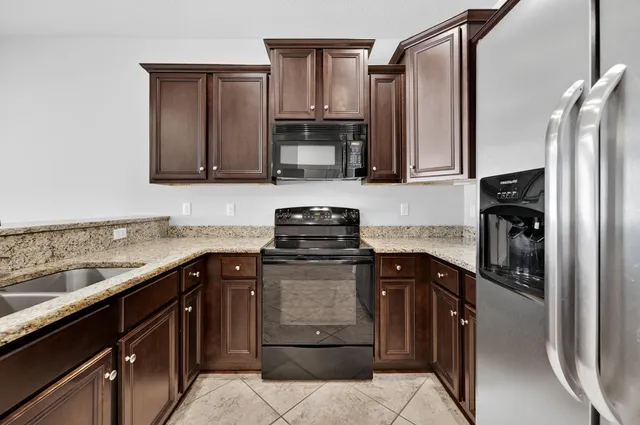 a kitchen with stainless steel appliances granite countertop a refrigerator and a sink