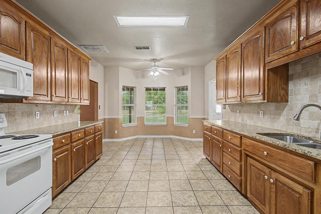 483 Christy Kay Lane Rhome, TX 76078 - Photo 14 of 40 a large kitchen with stainless steel appliances granite countertop a stove and a sink