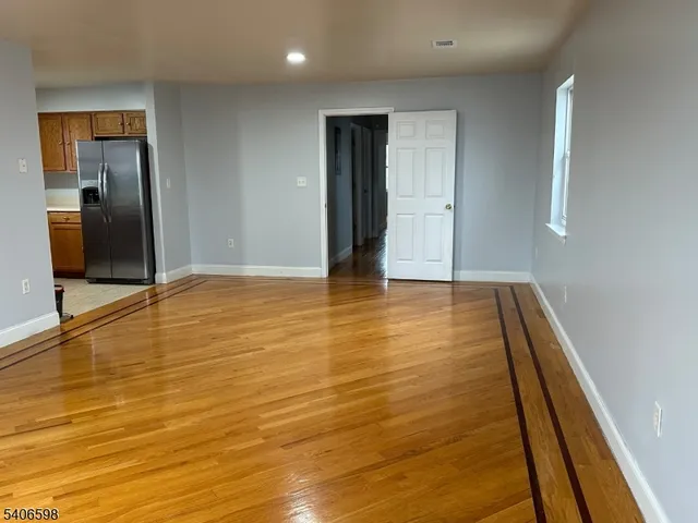 a view of an empty room with wooden floor