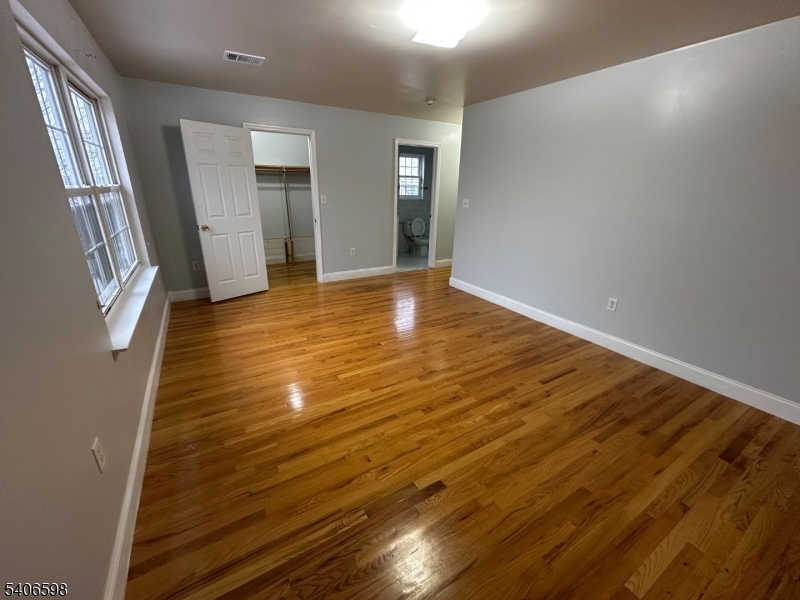 448 Catherine Street Elizabeth, NJ 07201 - Photo 9 of 11 a view of an empty room with wooden floor and a window