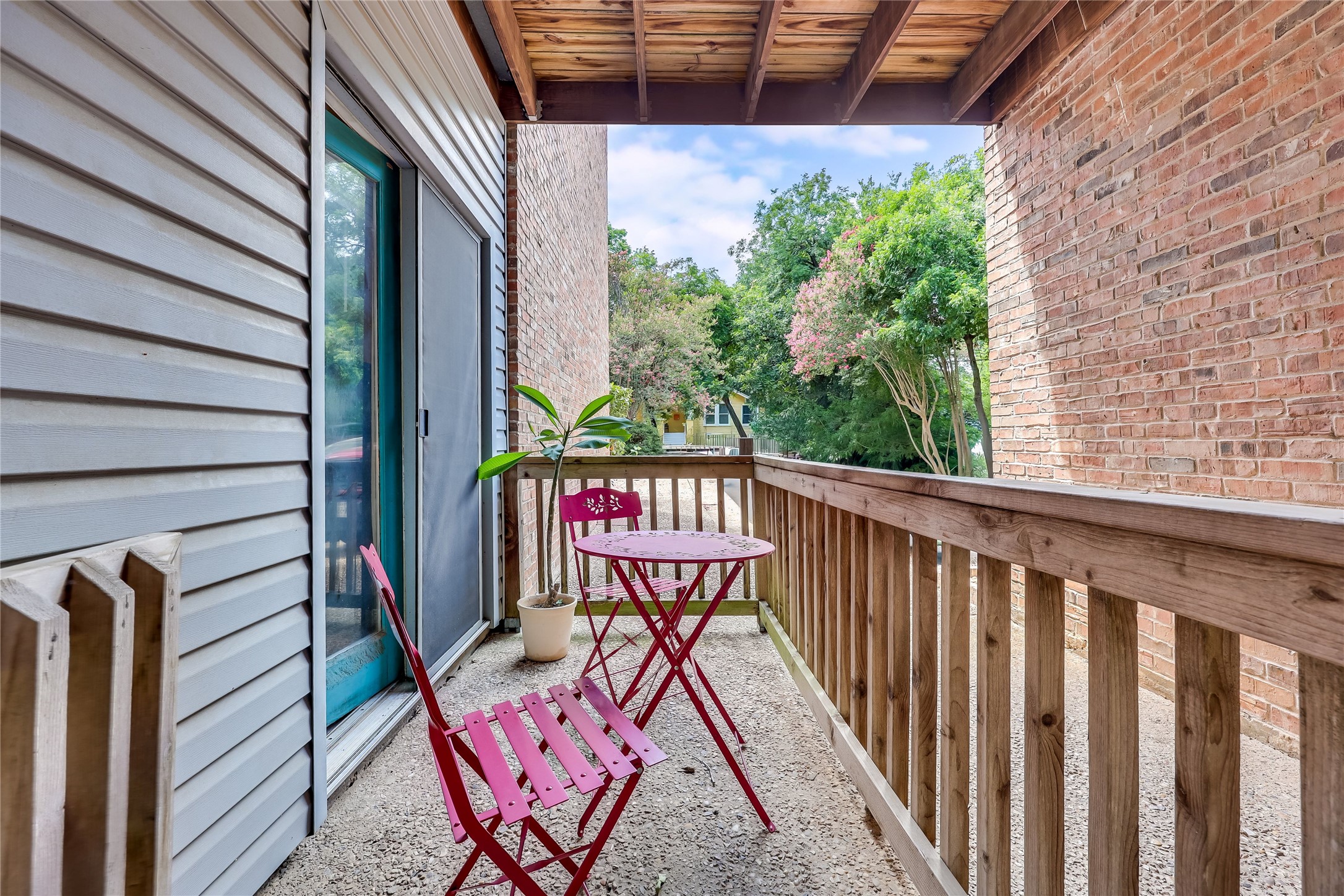 3011 Fruth Street, Unit 101 Austin, TX 78705 - Photo 12 of 14 A private, covered balcony offers a tranquil retreat amidst a lush green backdrop.