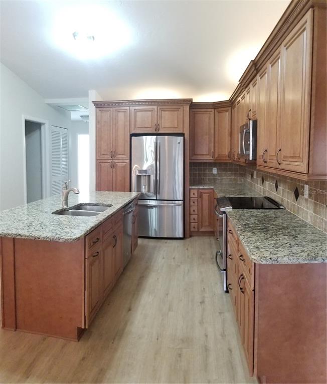 5810 Garden Lakes Majestic Bradenton, FL 34203 - Photo 7 of 28 a kitchen with stainless steel appliances granite countertop a sink stove and refrigerator