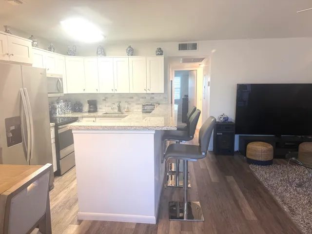 a kitchen with a table chairs refrigerator and a sink