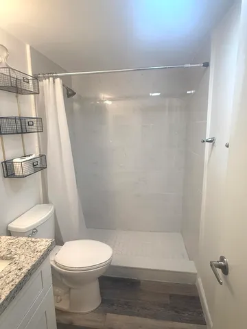a bathroom with a granite countertop sink toilet and shower