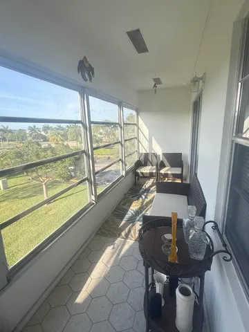 a view of a living room with furniture and floor to ceiling windows