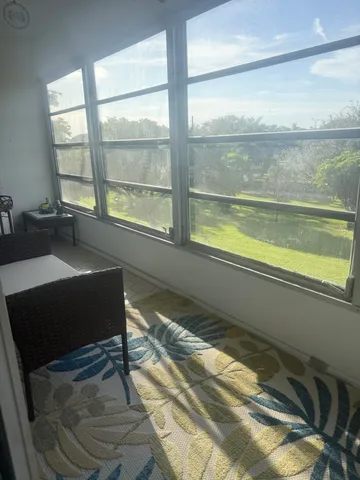 a living room with a floor to ceiling window and a table