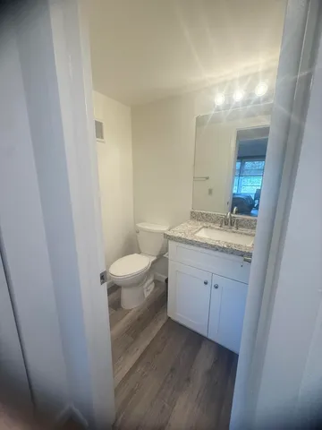 a bathroom with a granite countertop sink toilet and shower