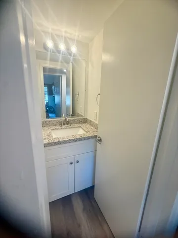 a bathroom with a granite countertop sink and a mirror