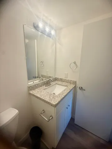 a bathroom with a granite countertop sink and a mirror