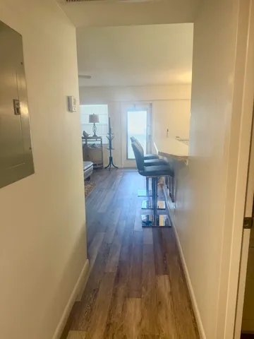 a view of a hallway with wooden floor and furniture