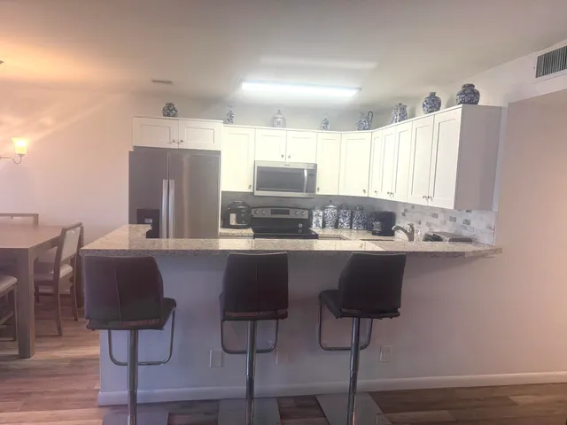 a kitchen with stainless steel appliances granite countertop a sink and a refrigerator