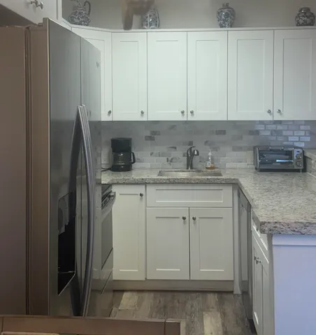 a kitchen with white cabinets and sink