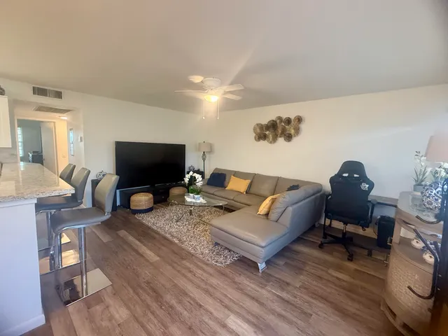 a living room with furniture a flat screen tv and a table